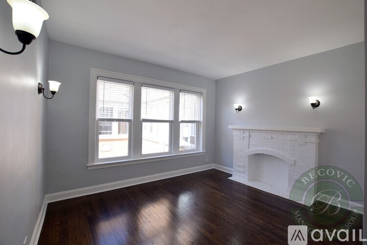 A room with a fireplace and two windows.