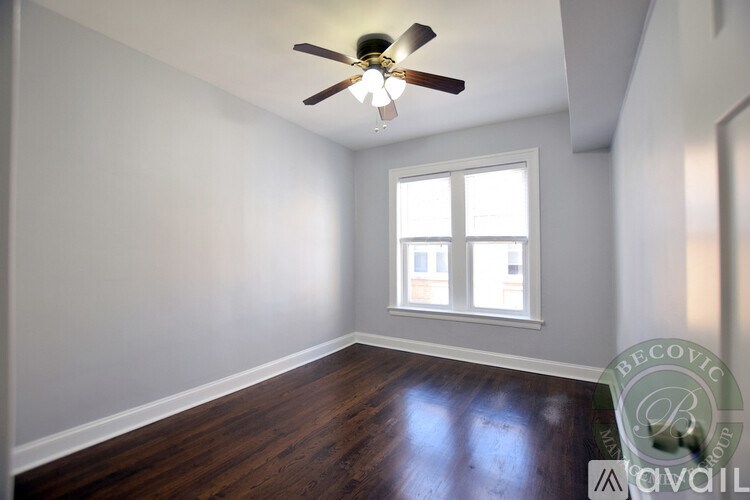 A room with a ceiling fan and a window.