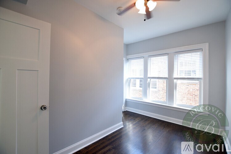 A room with a door, a window, and a ceiling fan.