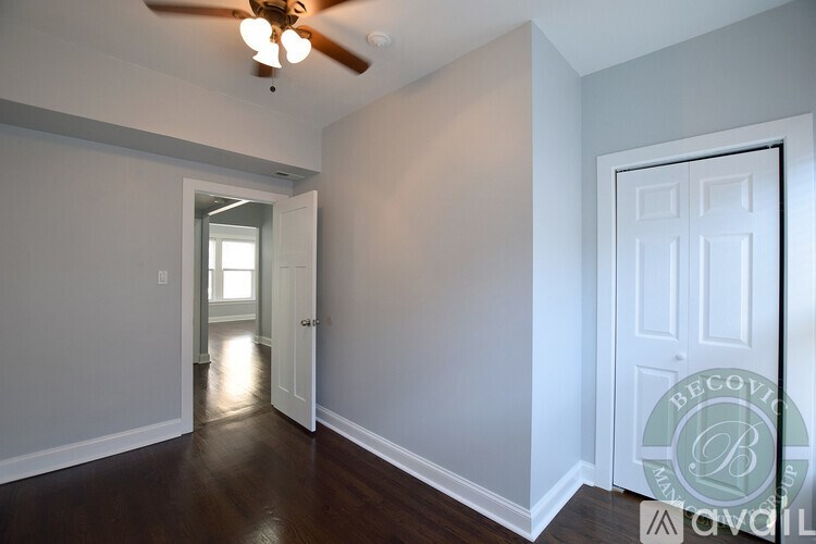 A room with a ceiling fan and a door.