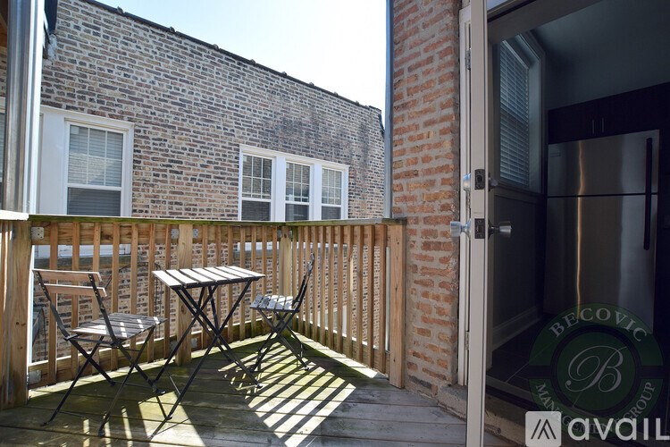 A patio with a table and chairs is shown with a building in the background.