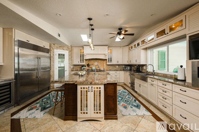 A kitchen with a marble countertop and stainless steel appliances.