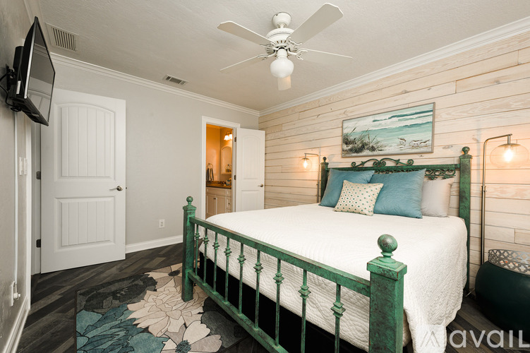 A bedroom with a green bed frame and a ceiling fan.