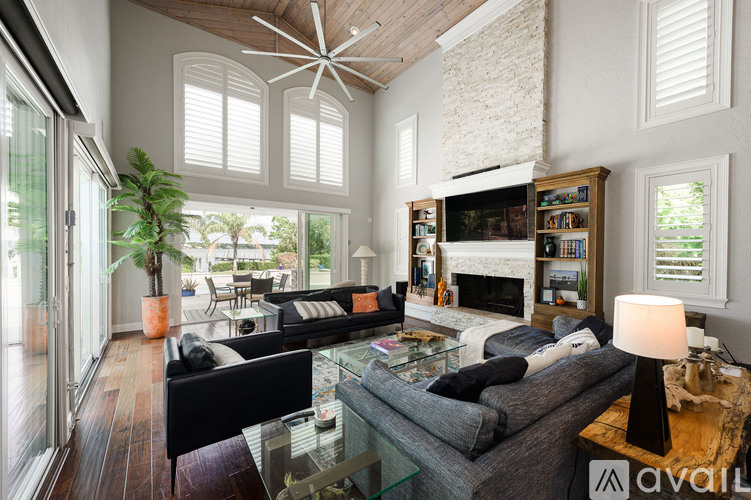 A living room with a glass table and a grey couch.