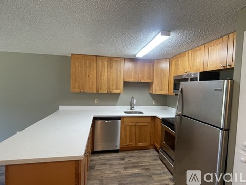 A kitchen with wooden cabinets and stainless steel appliances.
