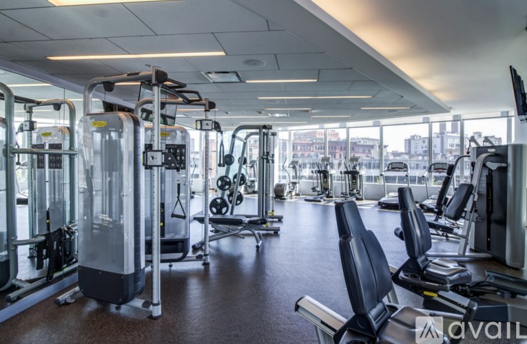 A gym with a variety of equipment including treadmills, weights, and exercise machines.