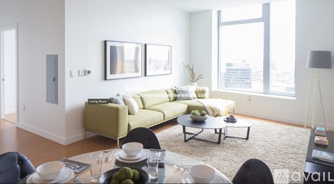 A living room with a sofa, coffee table, and a dining table set for two.