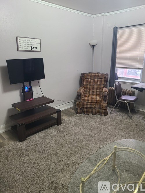 A living room with a couch, chair, and television.