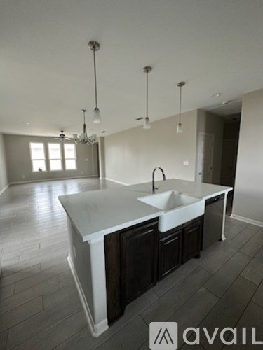 A modern kitchen with a large island and a chandelier.