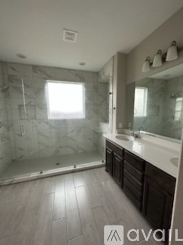 A bathroom with a marble shower and a sink.