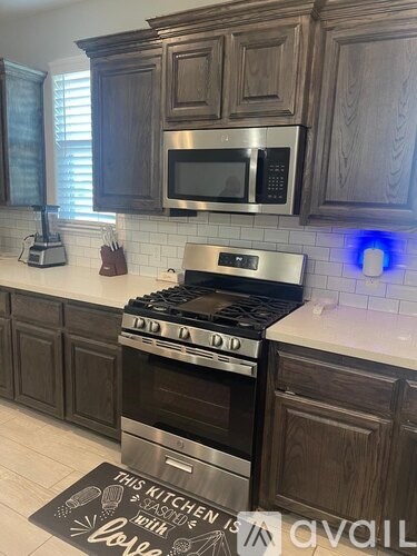 A kitchen with a stove top oven and a microwave above it.
