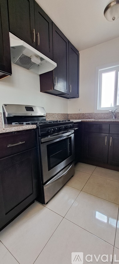A kitchen with black cabinets and a stove top oven.