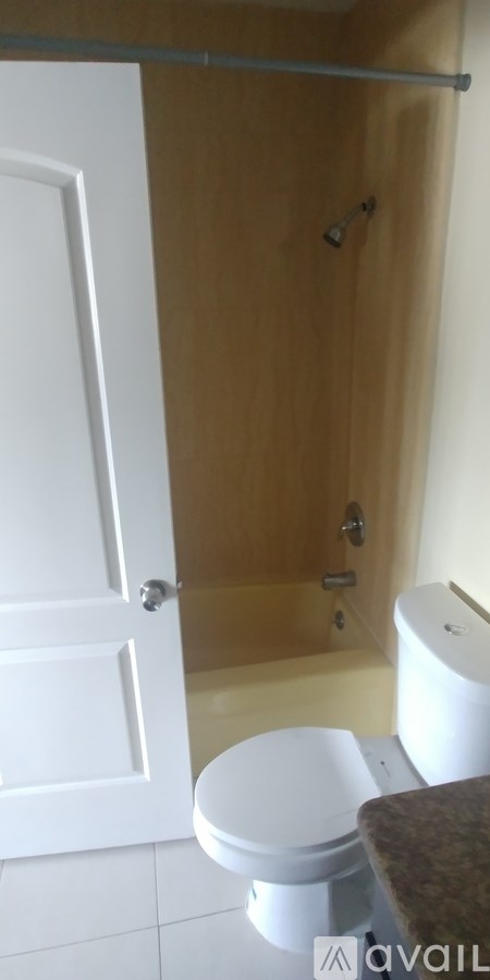 A white toilet sits in a bathroom next to a walk-in shower.