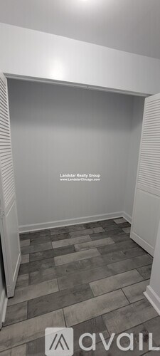 A room with a wooden floor and a white wall.