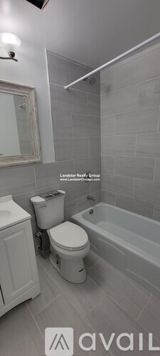 A bathroom with a toilet, a bathtub, and a mirror.