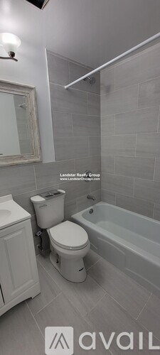 A bathroom with a toilet, a bathtub, and a mirror.