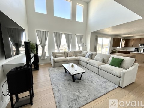 A living room with a white couch and a black television.