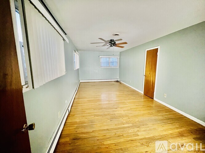 A room with wooden floors and a ceiling fan.
