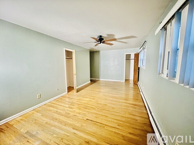 A room with wooden floors and a ceiling fan.