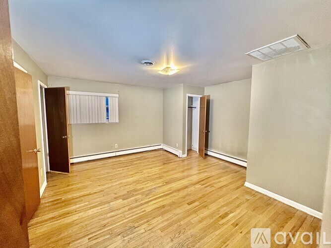 A room with wooden flooring and a ceiling light.
