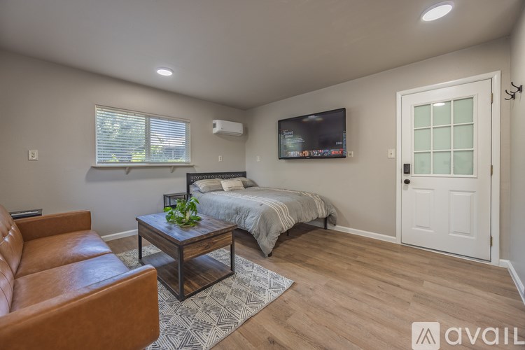 A bedroom with a bed, a couch, and a coffee table.