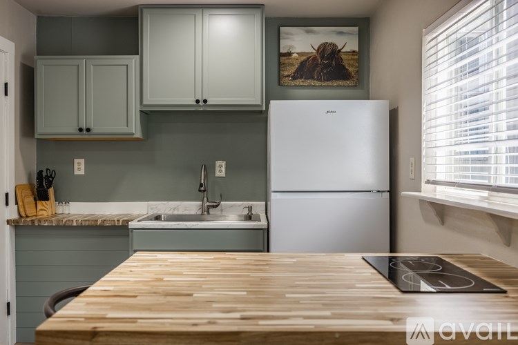 A kitchen with a white fridge and wooden table.