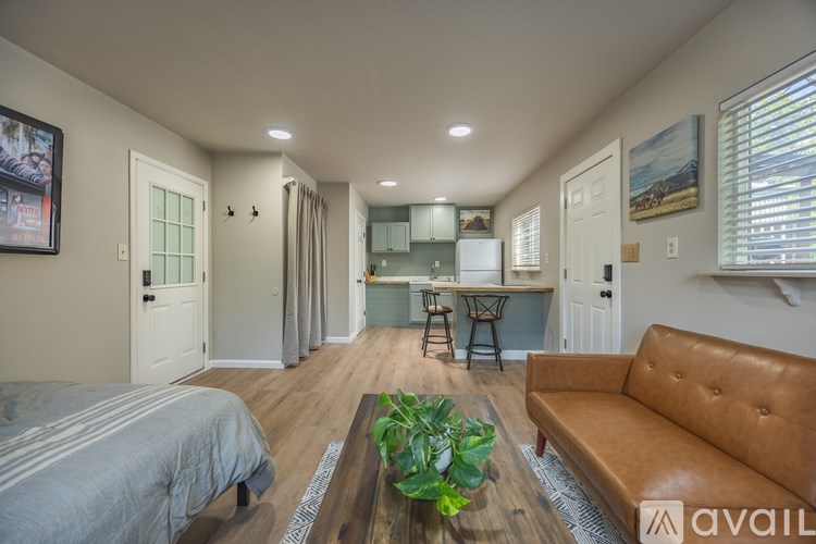A living room with a couch, a bed, and a dining table.