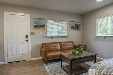 A living room with a brown leather couch and a wooden coffee table.