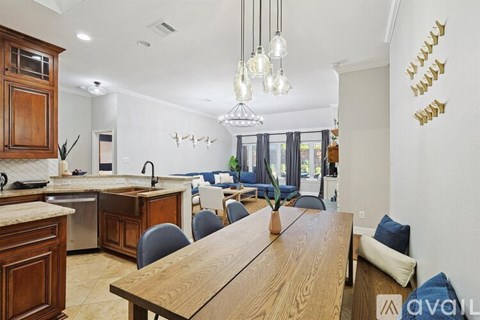 A kitchen with a dining table and chairs in the foreground.