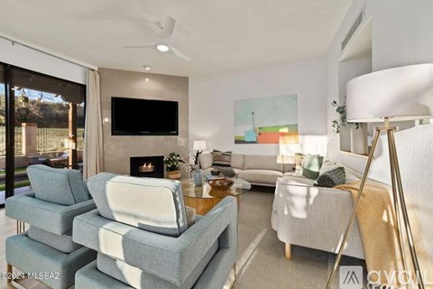 A living room with a grey couch, a grey chair and a television.