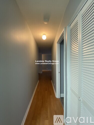 A hallway with a wooden floor and white walls.