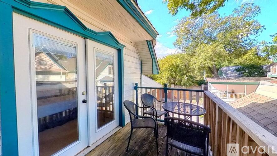 A balcony with a table and chairs overlooking a pool.