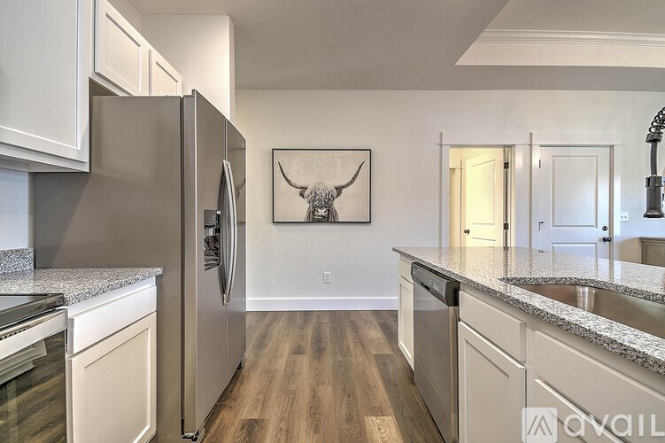 A kitchen with a refrigerator, oven, and sink.
