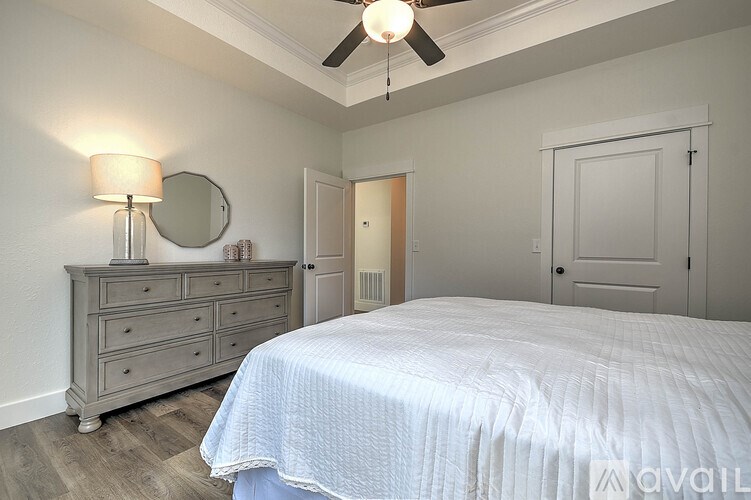 A bedroom with a bed, dresser, and mirror.