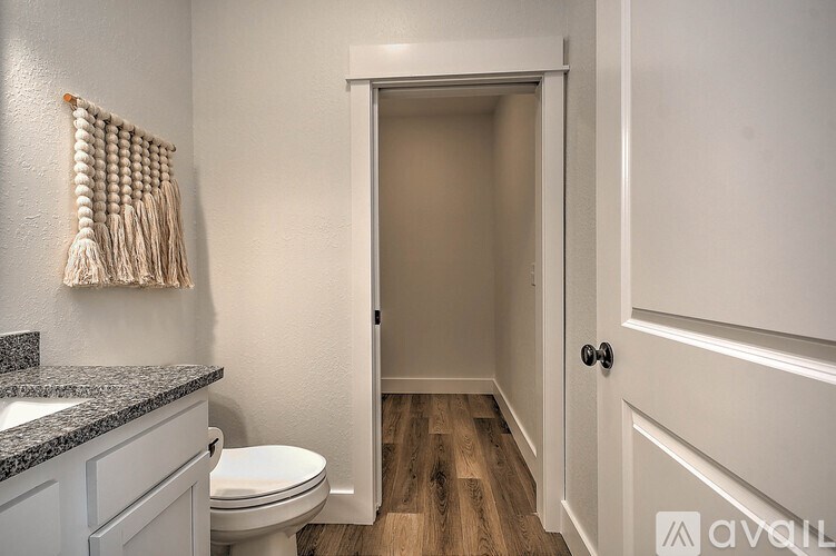 A bathroom with a toilet, sink, and a door.