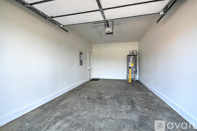 A large empty room with a concrete floor and white walls.