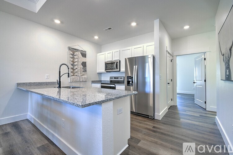 A kitchen with a granite countertop and stainless steel appliances.