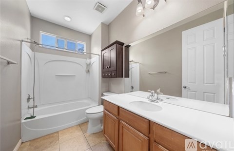 A bathroom with a white tub, sink, and toilet.