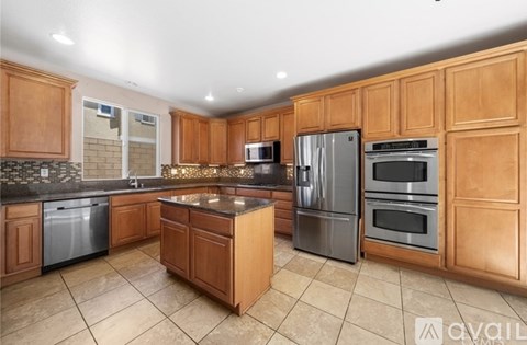 A kitchen with wooden cabinets and a granite countertop.