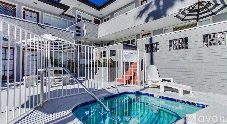 A pool with a diving board and a white chair.