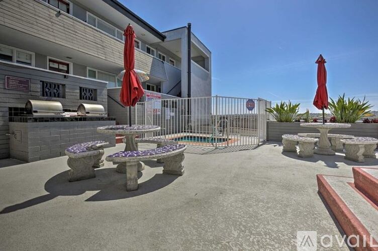 A patio area with tables and chairs and umbrellas.