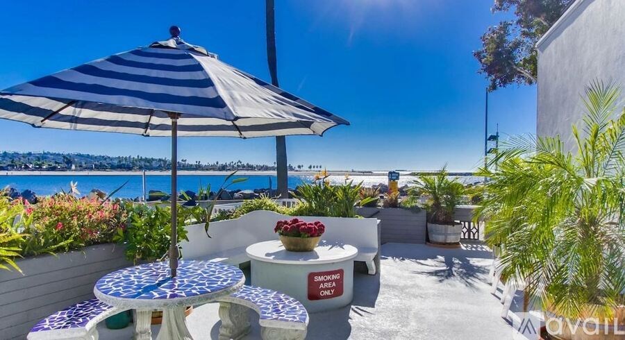 A blue and white striped umbrella is on a patio table.