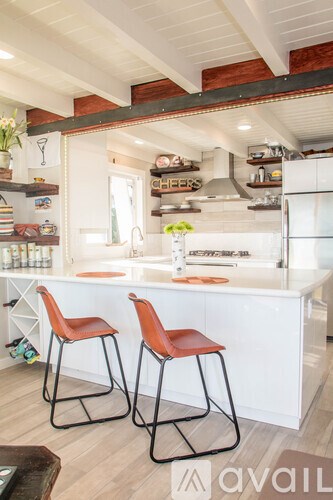 Two bar stools are in front of a kitchen island.
