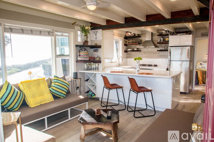 A kitchen with a white counter and bar stools.