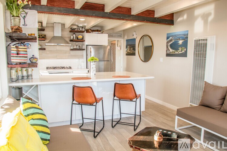 A kitchen with a white countertop and orange chairs.