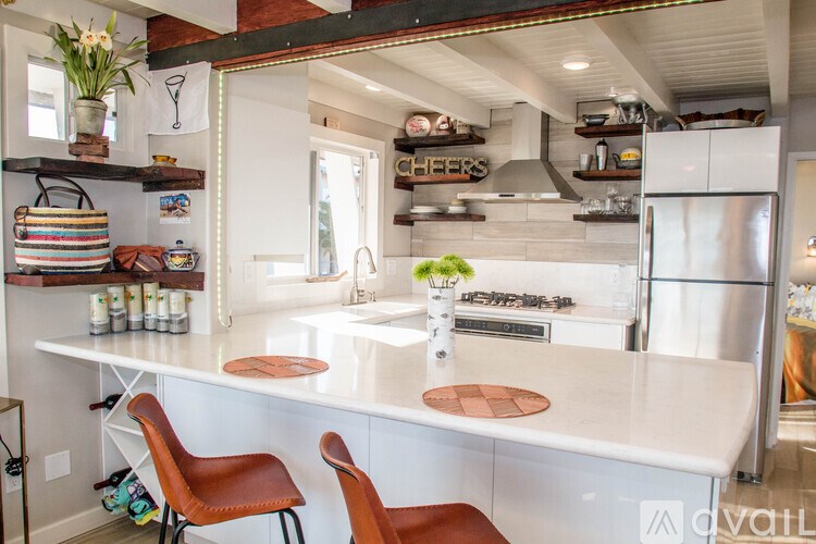 A kitchen with a white countertop and orange chairs.