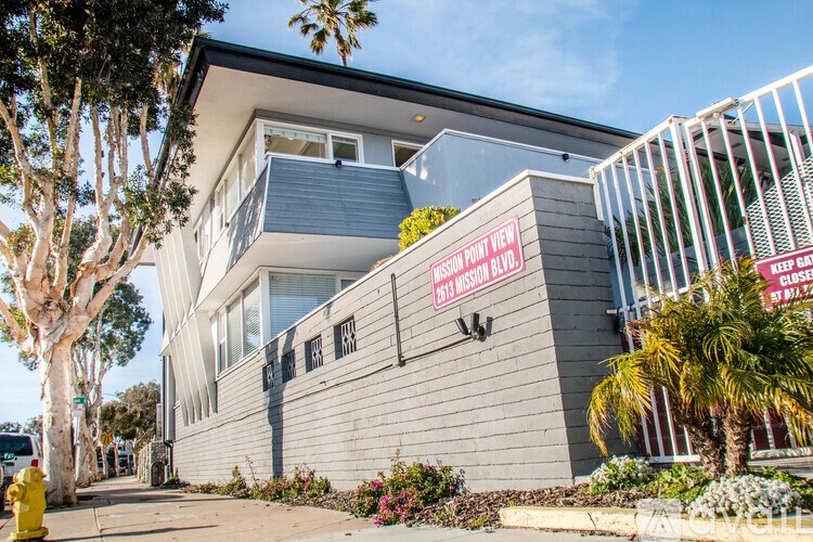 A modern building with a sign that says "Keep Grass Short".