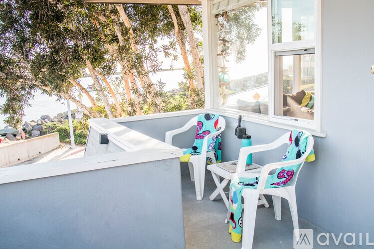 Two chairs with floral patterns are placed on a balcony.