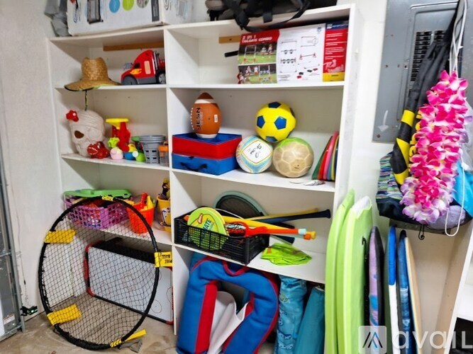 A white shelf with toys and sports balls.