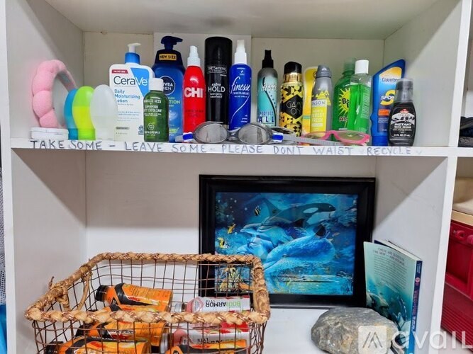 A bathroom shelf with a sign that says "Take some - Leave some - Please don't waste - Recycle."